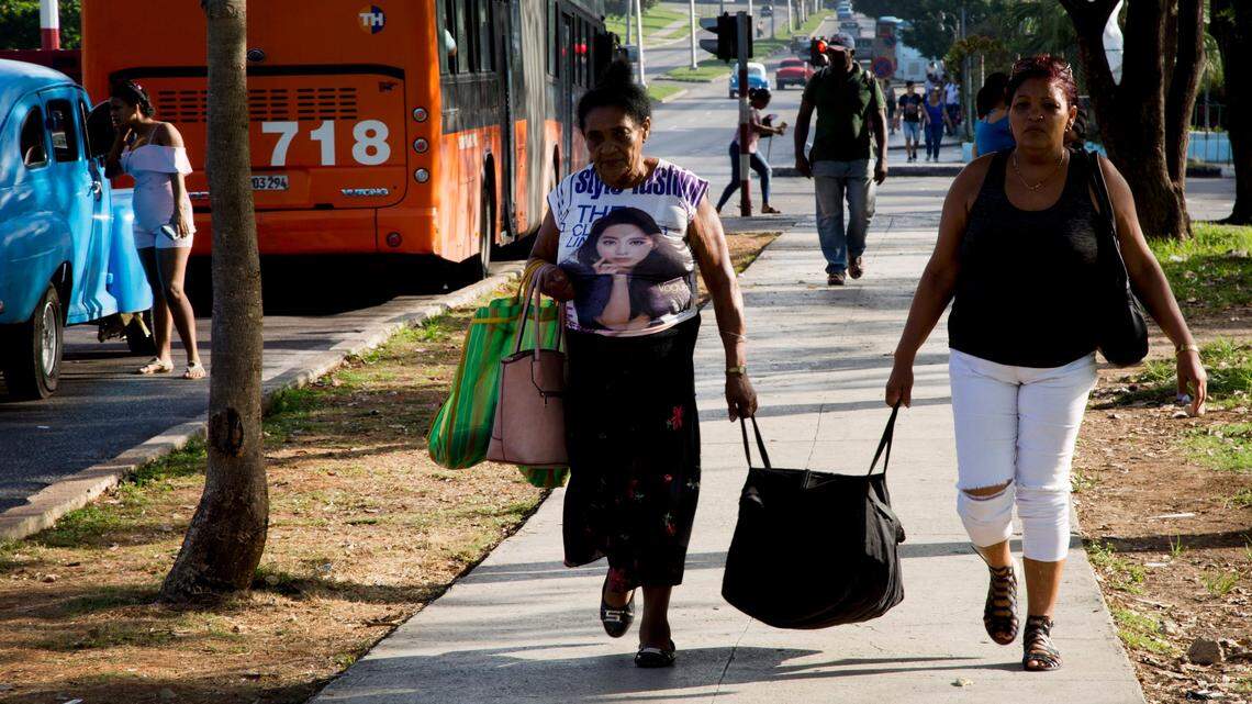Unas mujeres llevan una bolsa después de llegar en autobús a La Habana, Cuba, el jueves 27 de junio de 2019.