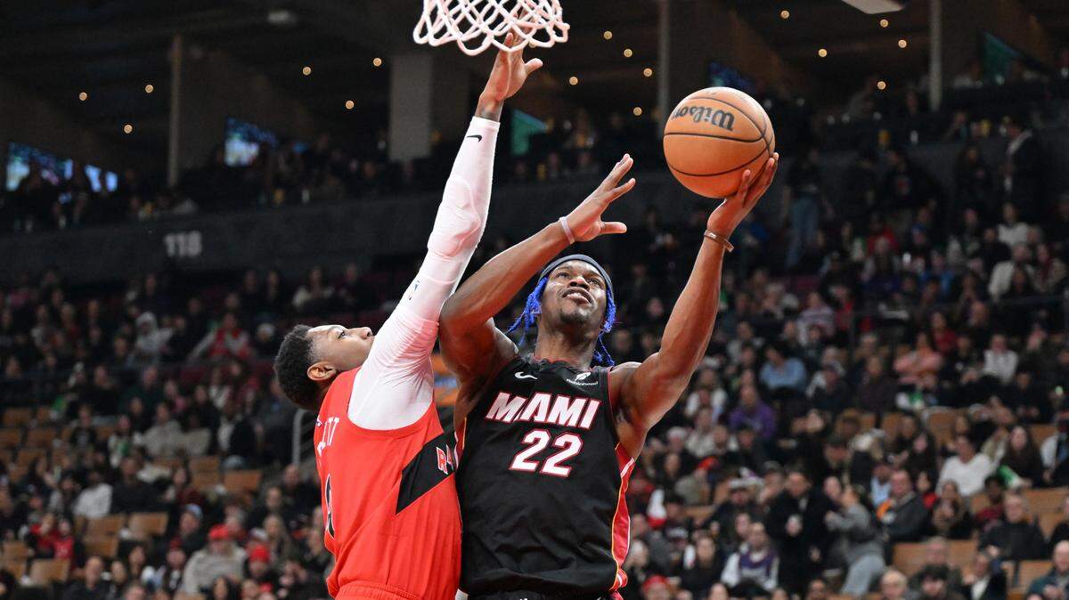 El jugador del Heat de Miami Jimmy Butler tira al aro ante la marca de RJ Barrett, de los Raptors, en el partido celebrado el 1ro de diciembre de 2024 en el Scotiabank Arena en Toronto.