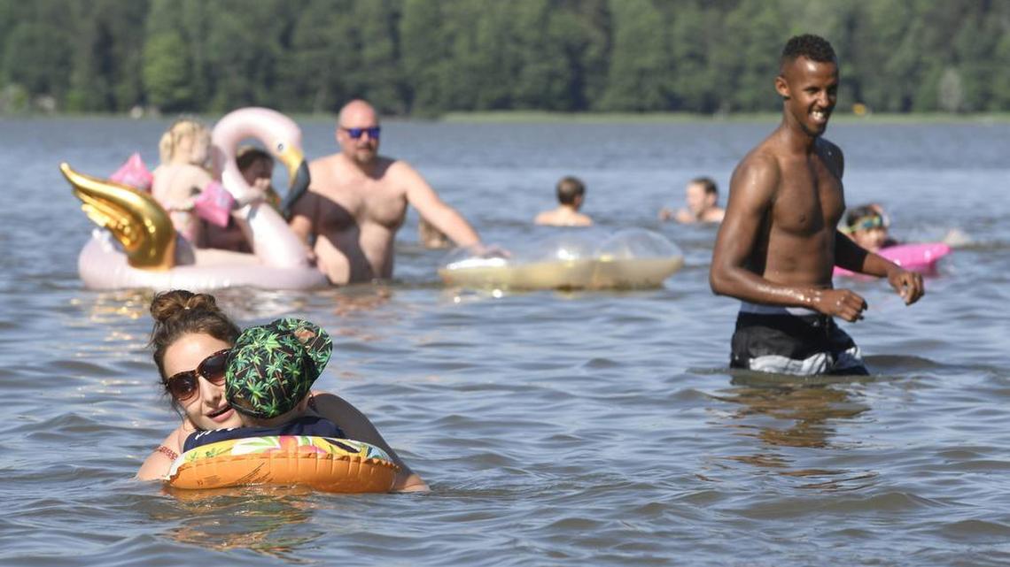 LOS MAS felices: La gente disfruta de un caluroso día de verano en un lago en Espoo, Finlandia, el 26 de junio de 2020.