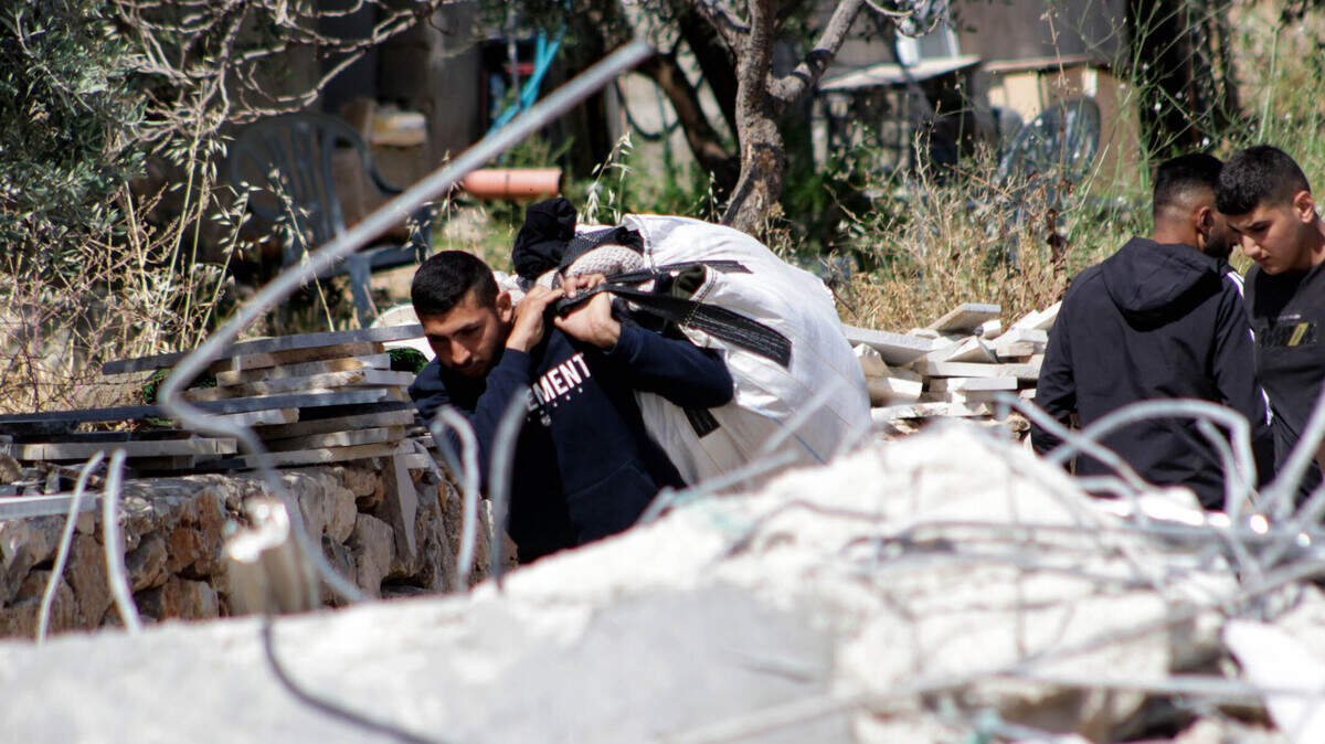 Un hombre palestino retira objetos después de que excavadoras israelíes demolieran un edificio palestino en la aldea de Qibya, al oeste de la ciudad de Ramallah, en Cisjordania, el 29 de abril de 2025.