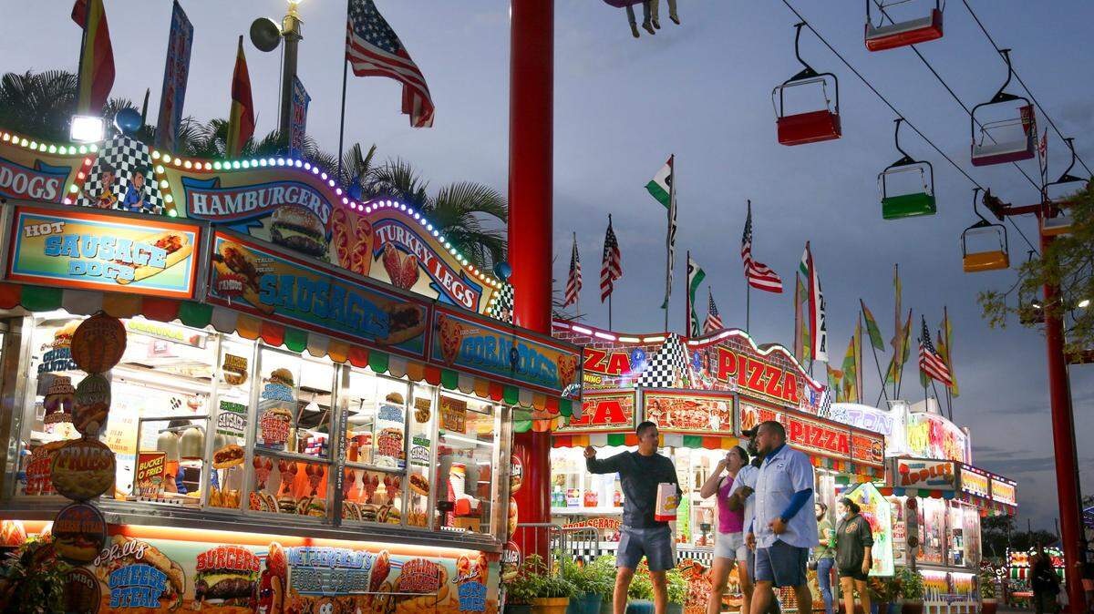 Fairgoers walk by the concession stands during the opening day of the Miami-Dade County Youth Fair at the Miami-Dade Fair & Expo Center in Miami, Florida, on Thursday, March 17, 2022.