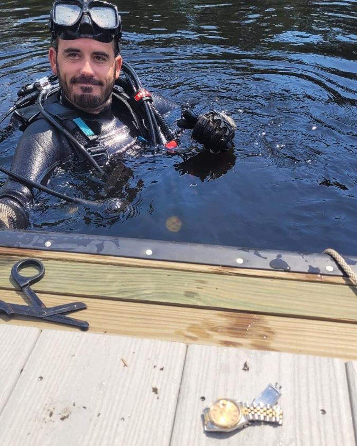 Un buzo del equipo del Departamento de Policía de de St. Johns County, Florida, posa sonriente tras recuperar el reloj de $16,00 del arroyo el miércoles 22 de junio de 2022.
