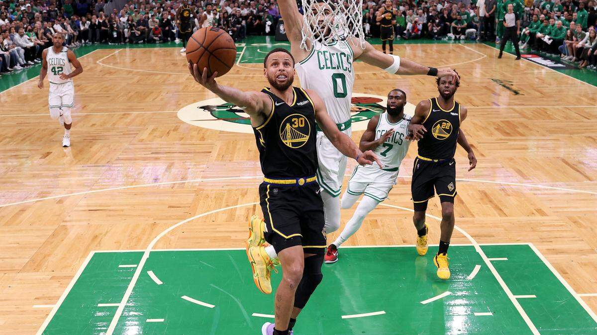 El escolta de los Warriors, Stephen Curry (#30) entra al aro con la marca de Jayson Tatum, de los Celtics, en el cuarto juego de la Final de la NBA celebrado el 10 de junio de 2022 en Boston.