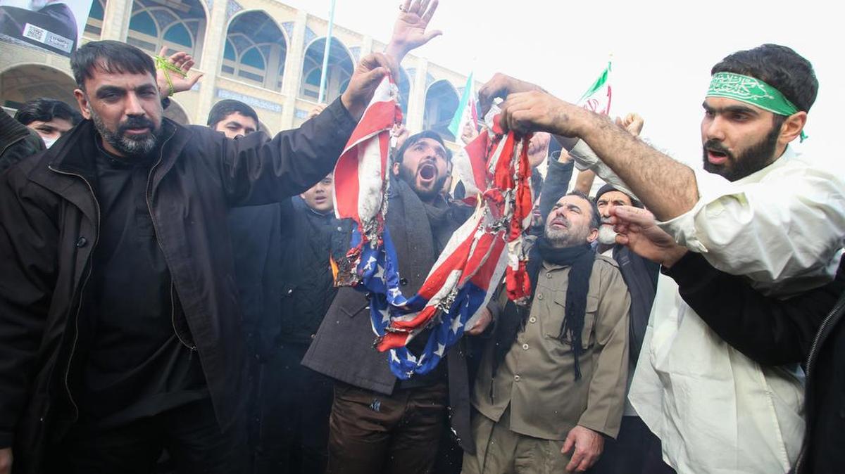 Iraníes queman una bandera estadounidense durante una manifestación contra los “crímenes” estadounidenses en Teherán el 3 de enero de 2020 tras el asesinato del mayor general de la Guardia Revolucionaria iraní Qasem Soleimani en un ataque estadounidense contra su convoy en el aeropuerto internacional de Bagdad.