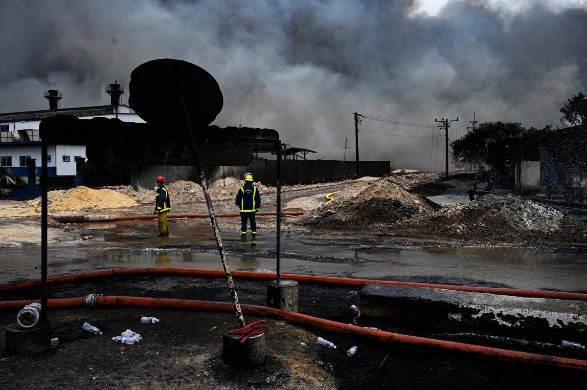 Los bomberos examinan el lugar de un incendio mortal en una gran instalación de almacenamiento de petróleo en Matanzas, Cuba, el martes 9 de agosto de 2022. El incendio se desencadenó cuando un rayo golpeó uno de los ocho tanques de la instalación el viernes 5 de agosto. (Yamil Lage, foto vía AP)