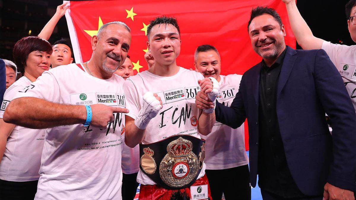 XU CAN junto a su entrenador Pedro Díaz (i) y el promotor Oscar de la Hoya tras vencer a Jesús Rojas el sábado.