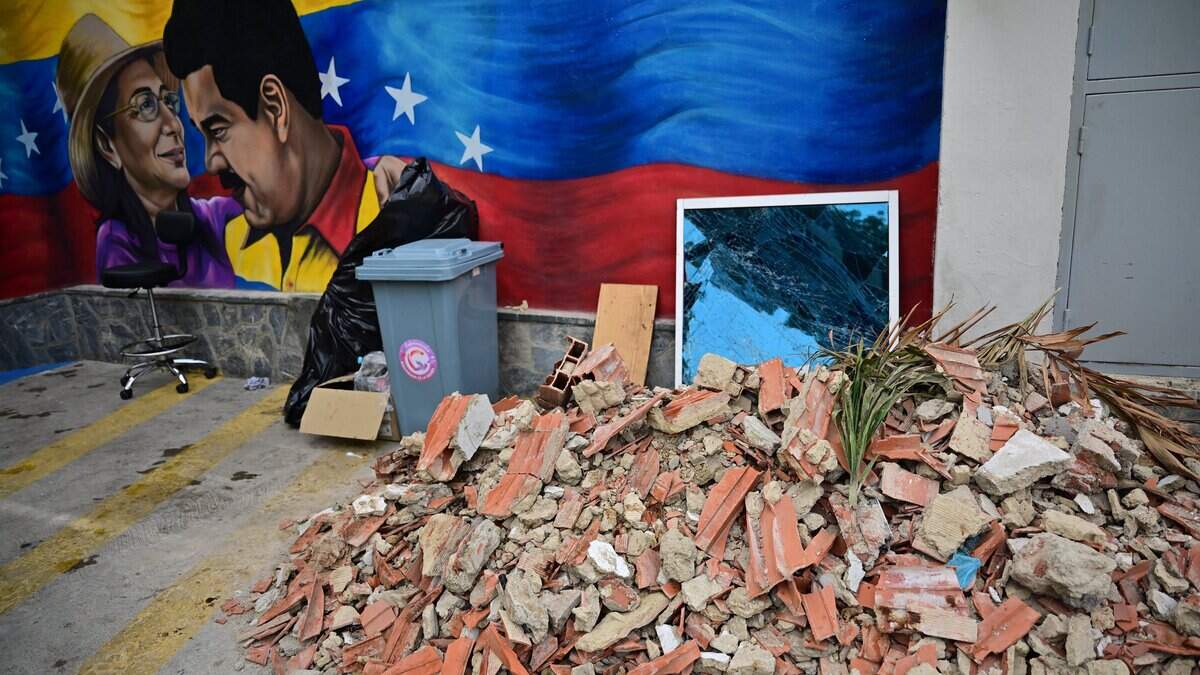 View of rubble next to a mural depicting Venezuela's ousted President Nicolas Maduro and his wife Cilia Flores in Caraballeda, La Guaira state, Venezuela, on July 5, 2026, following the June 24 twin earthquakes. The devastating earthquakes that struck Venezuela eleven days ago have now claimed nearly 3,000 lives, according to the latest figures released on July 4, 2026, as foreign rescue teams wind down their operations to find survivors. (Photo by MARTIN BERNETTI / AFP via Getty Images)