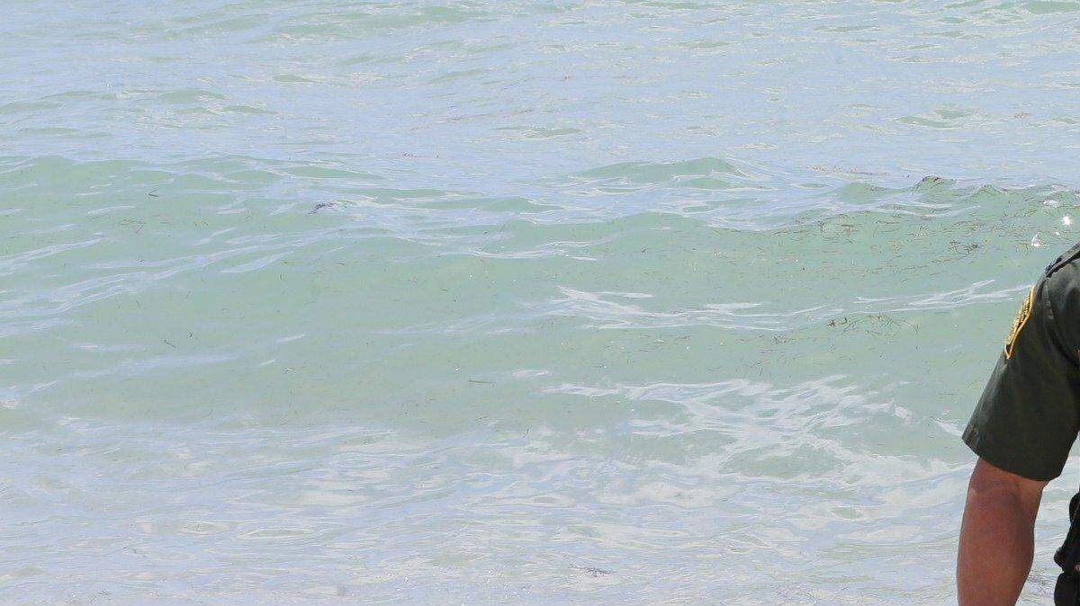 El agente J. Marlett, de Inmigración y Aduanas, junto al bote en donde llegaron dos cubanos el jueves a Miami Beach.