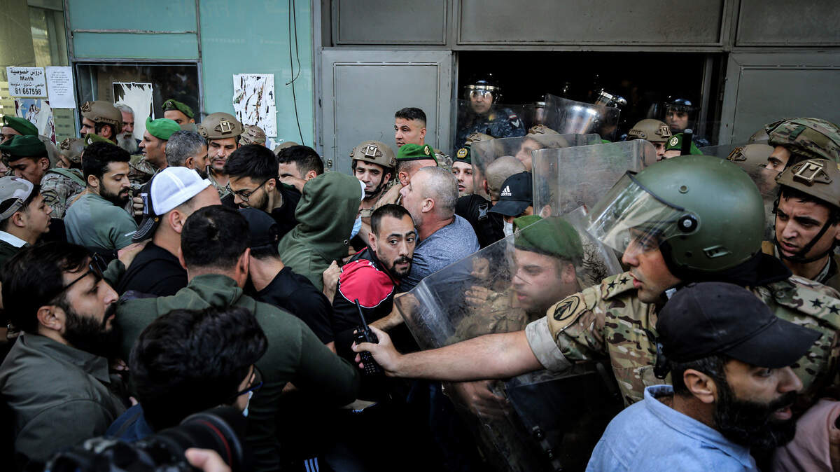 Soldados libaneses y personas que huyeron del sur del país debido conflicto entre Israel y Hezbolá se enfrentan frente a un hotel en Beirut, el lunes 21 de octubre de 2024. 