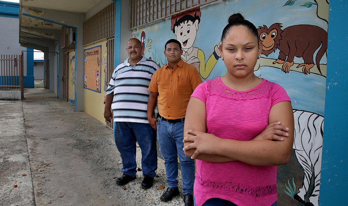 La alumna Genesis Velázquez afuera de su escuela a la que ha asistido desde muy pequeña, junto a su padre, Felipe Velázquez (extrema izquierda) y su primo Jafenier Velázquez, después que la escuela, la Marcos Sánchez, fue cerrada sin previo aviso en el municipio de Yabucoa.