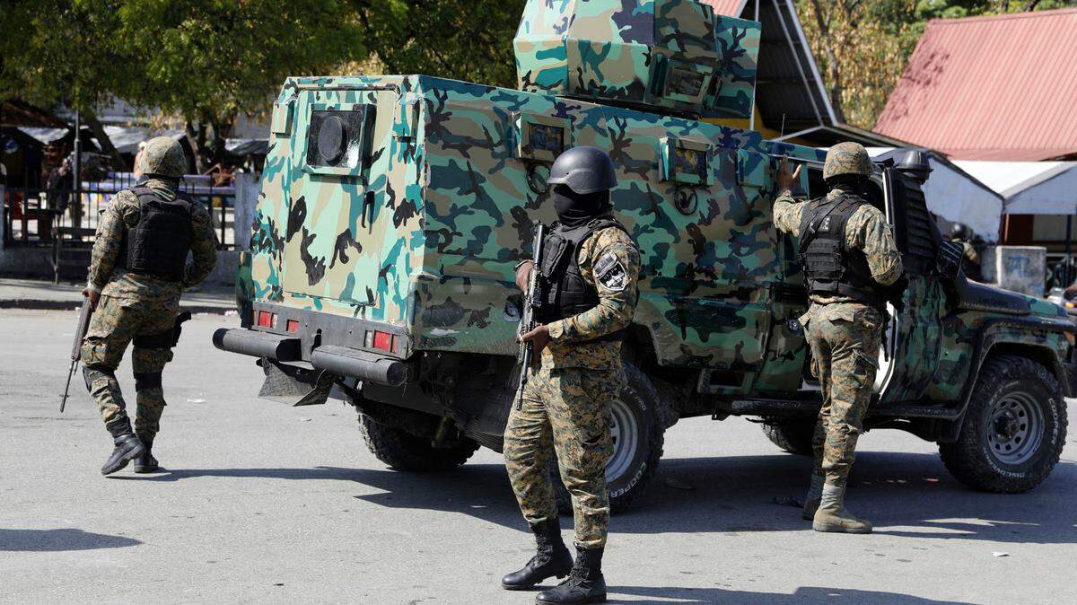 Miembros de la Unidad de Seguridad General del Palacio Nacional (USGPN) protegen tres estaciones policiales en el centro de Puerto Principe, Haití, el sábado 9 de marzo de 2024. 