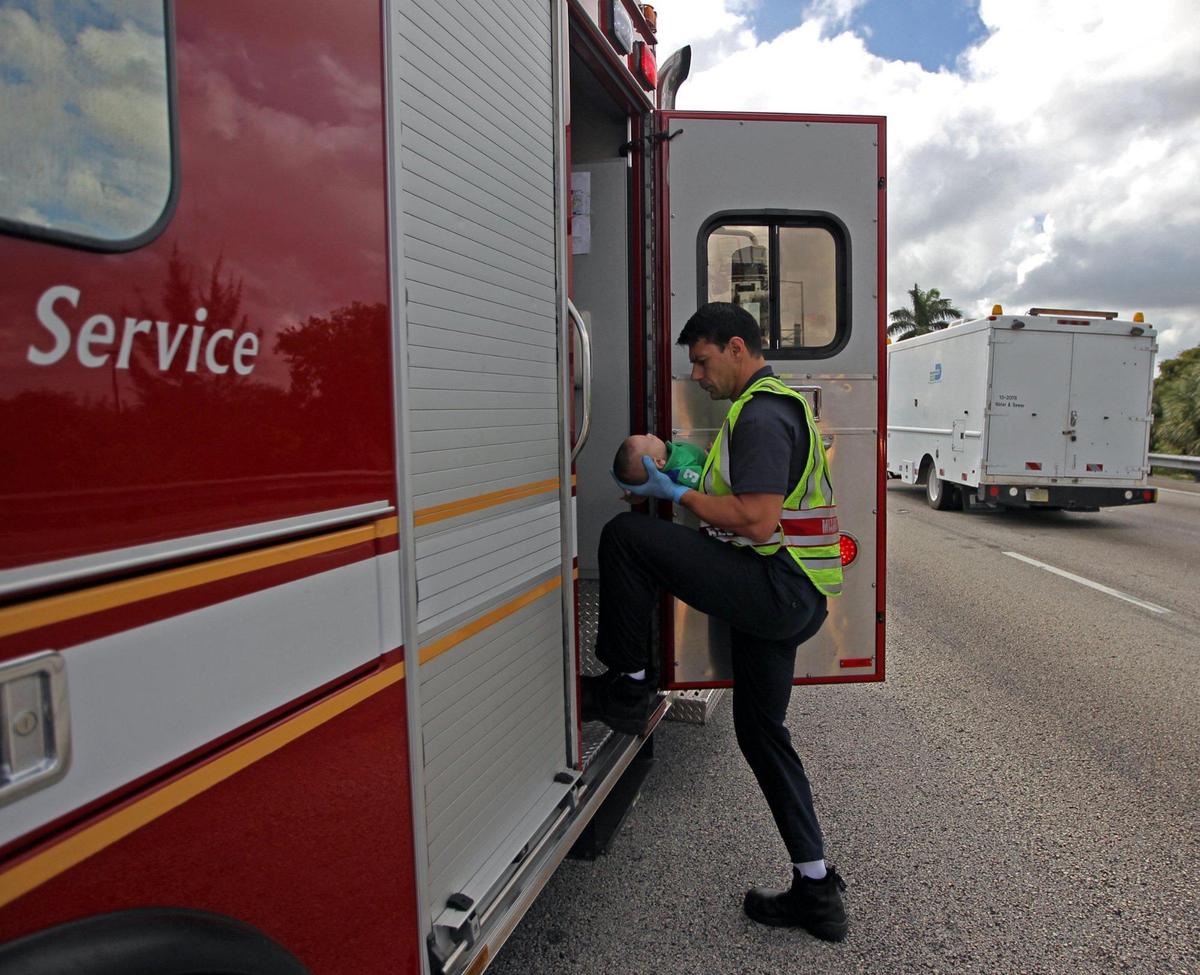 Foto de archivo de febrero de 2014 de un paramédico de Miami Fire Rescue transportando a un bebé que había dejado de respirar en la carretera estatal 836 al hospital.