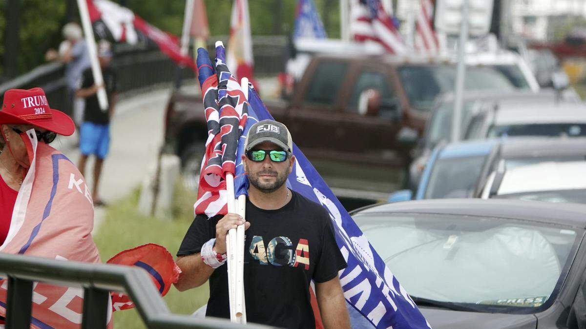 Partidarios del ex presidente Donald Trump caminan por Southern Boulevard, el martes 9 de agosto de 2022, para protestar por el registro del FBI en Mar-a-Lago en Palm Beach, Florida, el lunes. (Joe Cavaretta/Sun Sentinel del sur de Florida/TNS)