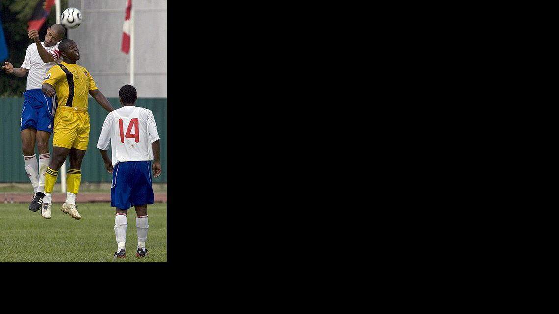 El cubano Reinier Alcántara (izq.) disputa el balón con el jugador de Antigua y Barbuda, Carr Dave, en los juegos clasificatorios para la Copa Mundial de la FIFA en Sudáfrica 2010.