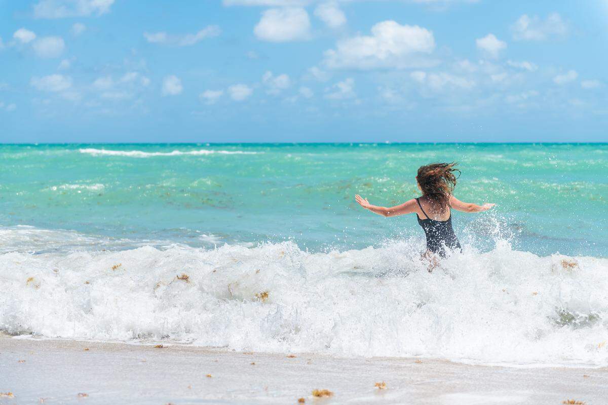 Una joven se refresca en el mar de Sunny Isles, Miami Beach.