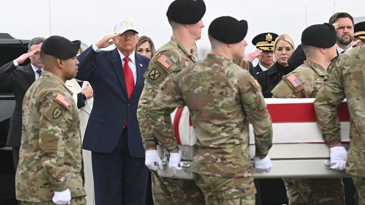El presidente de Estados Unidos, Donald Trump, saluda mientras miembros de un equipo del Ejército estadounidense transportan una caja de transferencia envuelta en una bandera que contiene los restos del sargento de primera clase Noah L. Tietjens durante un solemne acto de traslado en la Base Aérea de Dover, Delaware, el 7 de marzo de 2026.