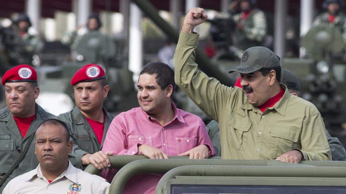Acompañado de su hijo Nicolás, el presidente venezolano Nicolás Maduro levanta el puño al llegar a un desfile militar en Caracas en abril del 2018.