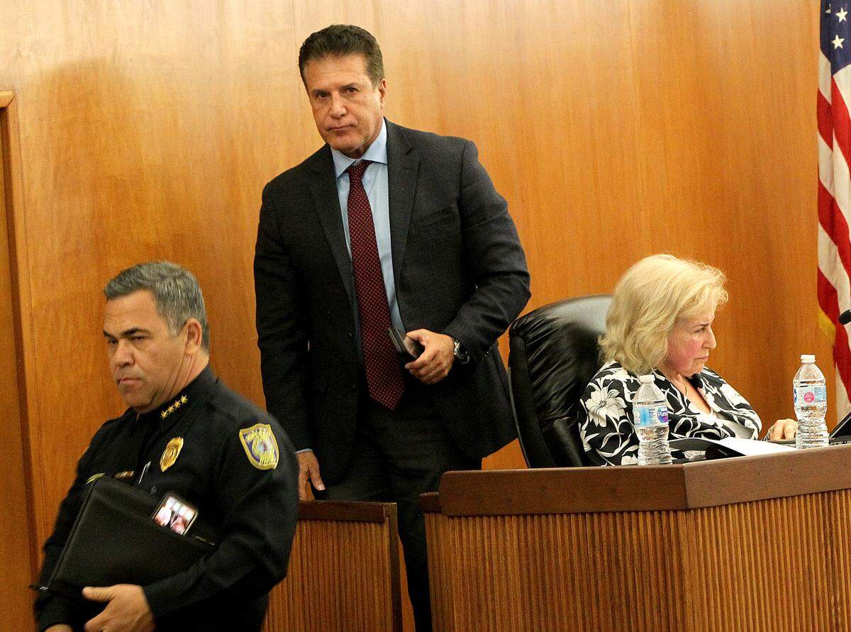 City of Hialeah Mayor Carlos Hernández leaves the chambers with City Police Chief Sergio Velázquez, during a City Council meeting on Tuesday, April 23, 2019.