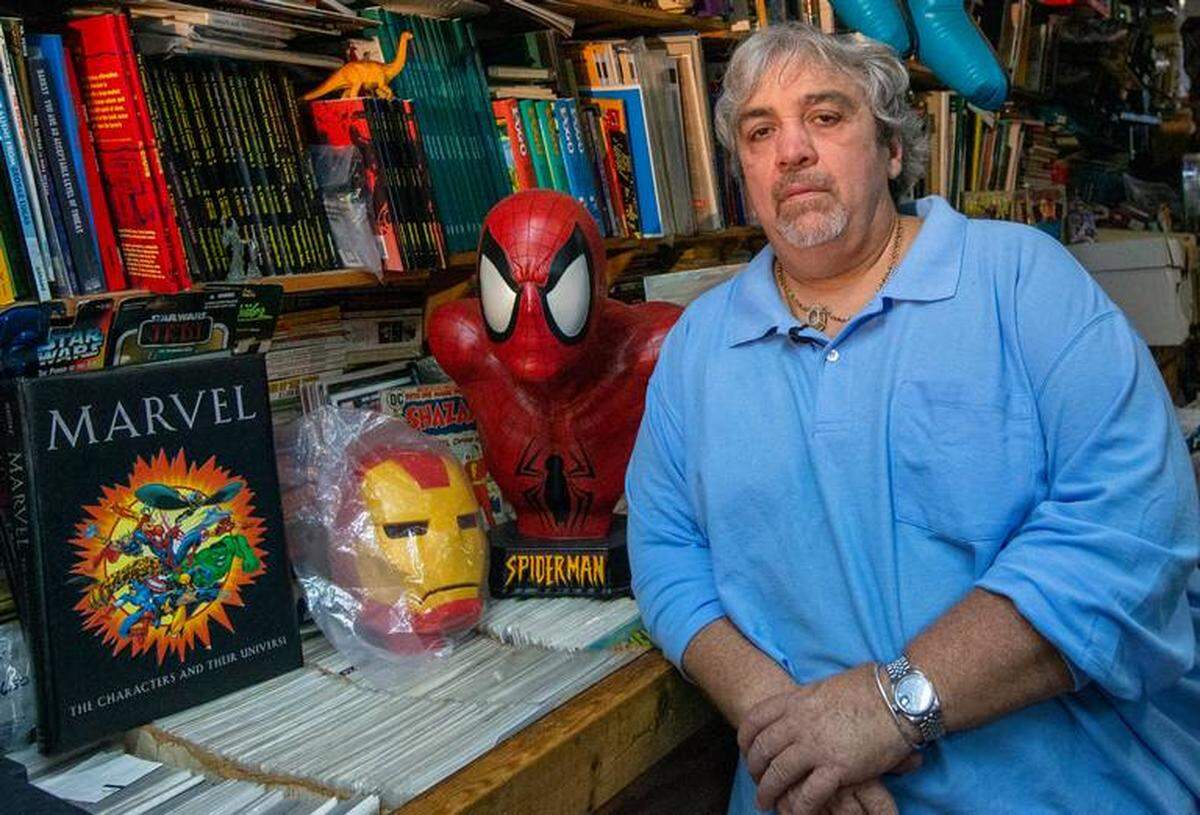 Jorge Pérez, dueño de la tienda A&M Comics and Books, posa junto a una máscara de Spider-Man en su local, ubicado en el 6650 Bird Road en Miami.