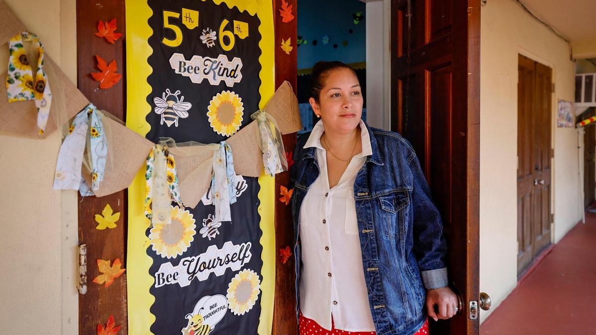 María Vásquez, maestra de quinto y sexto grado, se encuentra afuera de su salón de clases en Citi Christian Academy, en Miami, Florida, el viernes 1 de noviembre de 2024. Vásquez es un ejemplo de hogares que, debido a que ganan un poco más de lo debido, no pueden recibir beneficios estatales para el cuidado infantil.