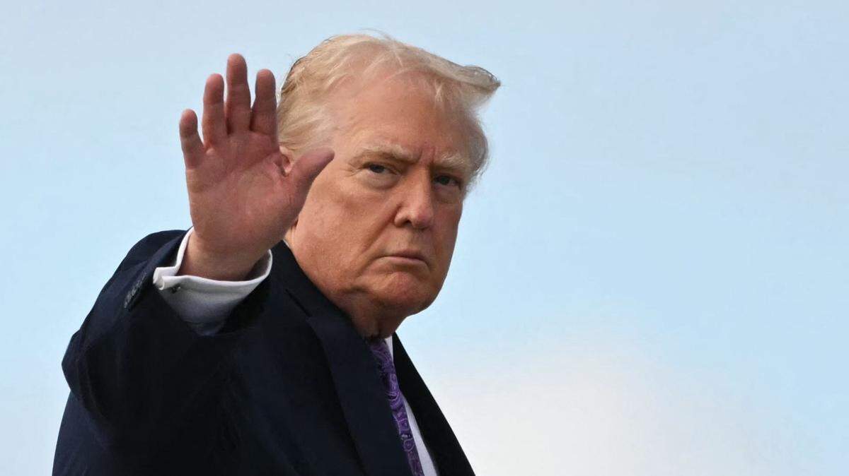US President Donald Trump waves while boarding Air Force One at Palm Beach International Airport on November 30, 2025, on his way back to Washington, DC. President Trump and First Lady Melania Trump spent the Thanksgiving holiday at his Mar-a-Lago residence. (Photo by Jim WATSON / AFP via Getty Images)