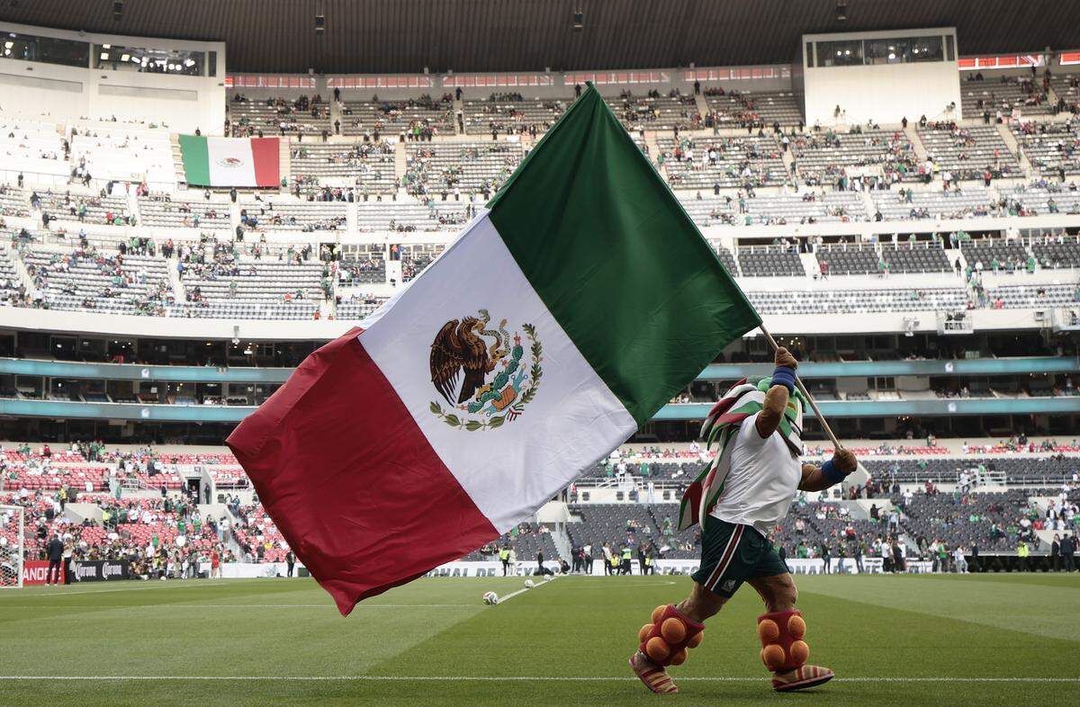 Un animador agita una bandera de México durante un partido amistoso entre México y Portugal en el estadio Azteca (Banorte) de Ciudad de México, el 29 de marzo de 2026. Este estadio será el primer recinto en albergar tres inauguraciones de Copas del Mundo, tras las de 1970 y 1986. 
