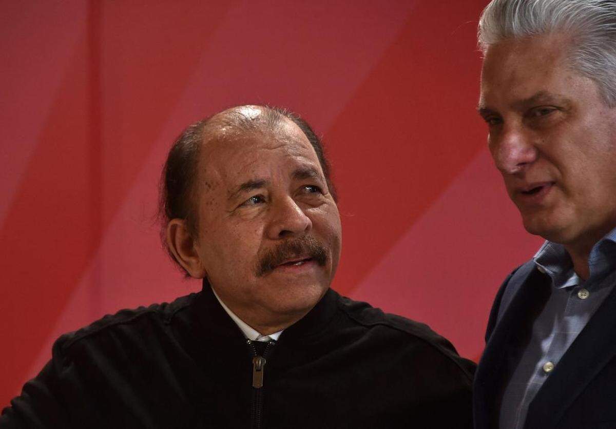 El gobernante cubano Miguel Díaz-Canel (d) recibe al presidente nicaragüense Daniel Ortega durante la XX Cumbre de la Alianza Bolivariana para los Pueblos de Nuestra América-Acuerdo Comercial de los Pueblos (ALBA-TCP), en el Palacio de la Revolución en La Habana el 14 de diciembre. 2021. (Foto de Adalberto ROQUE / POOL / AFP/ Getty Images)