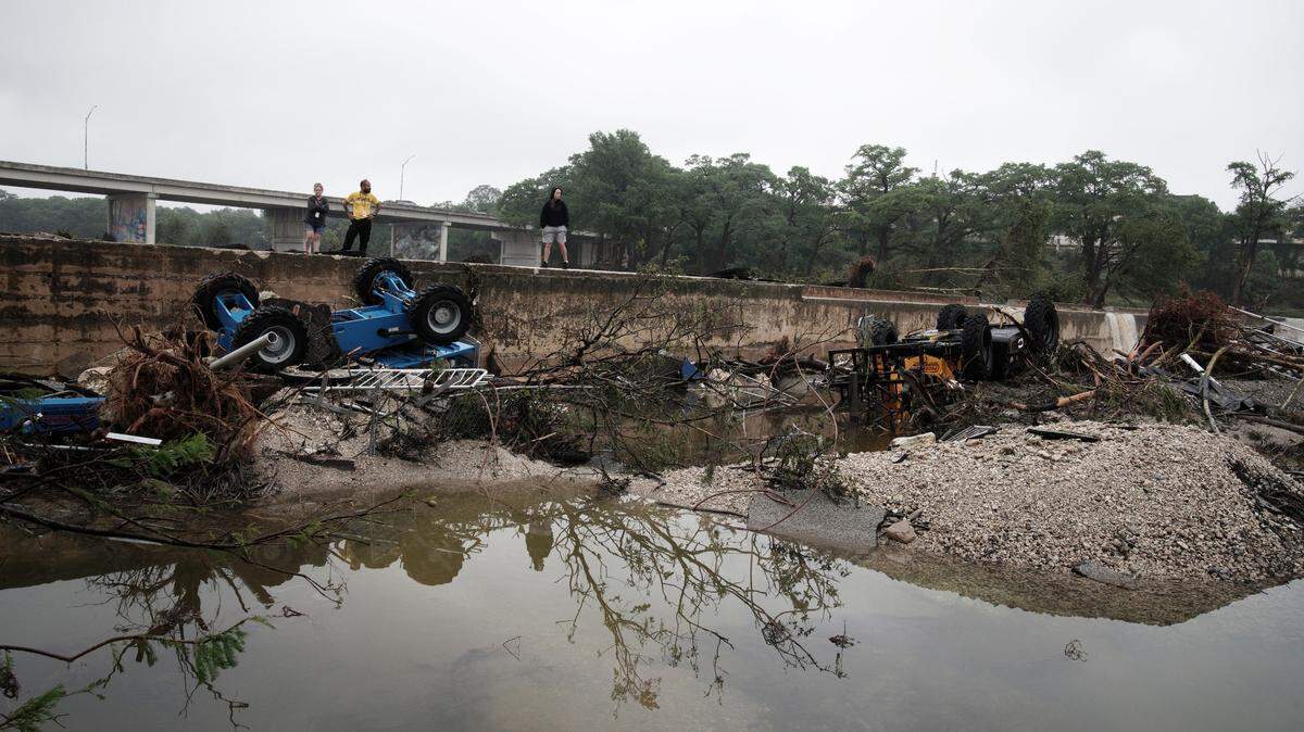 Personas observan los daños causados ​​por las inundaciones en Kerrville, Texas, EE. UU., el 5 de julio de 2025. Se confirmó la muerte de 59 personas y la desaparición de decenas después de que las aguas arrasaran un campamento de verano y viviendas cercanas la madrugada del 4 de julio. Los equipos de búsqueda y rescate continúan trabajando sin descanso tras las inundaciones repentinas en el río Guadalupe, en el condado de Kerr.