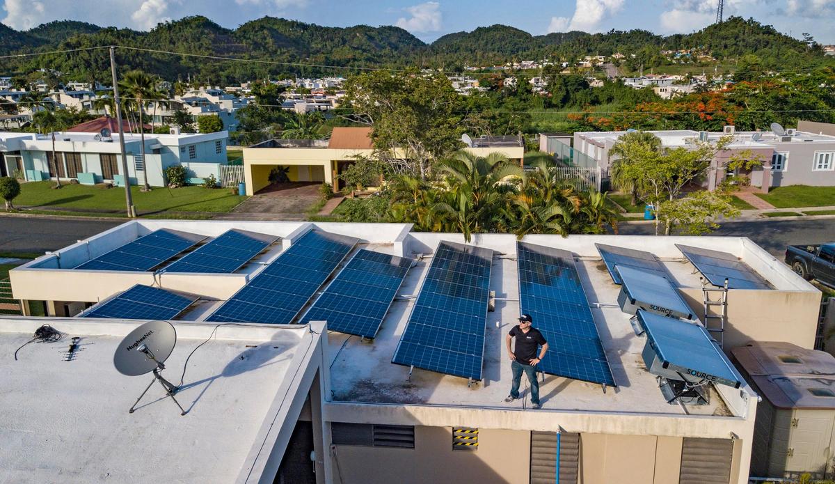 Israel Meléndez en el techo de su casa, cubierto de paneles solares, en Manatí, Puerto Rico.