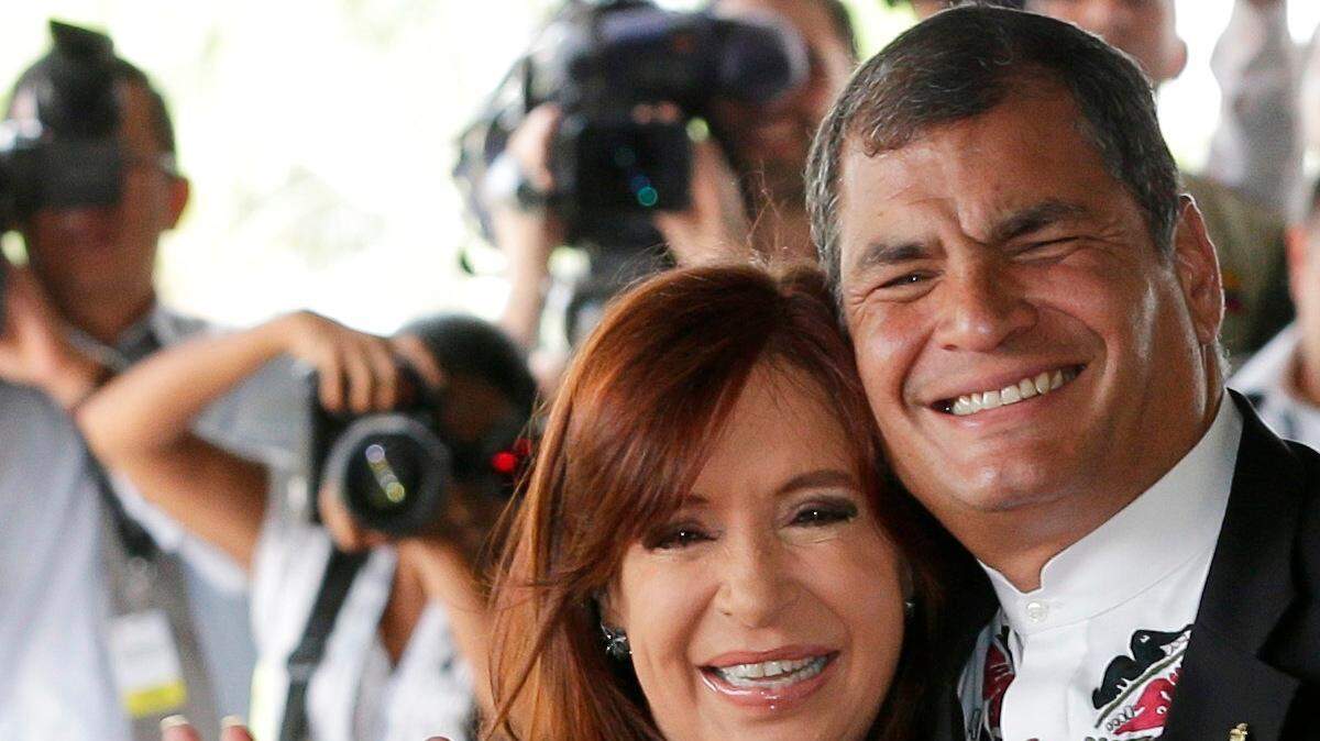 El presidente de Ecuador, Rafael Correa, derecha, abraza a la presidenta de Argentina, Cristina Fernández, frente a la prensa en el inicio de una reunión de la Unasur en Guayaquil, Ecuador, jueves, 4 de diciembre de 2014. 