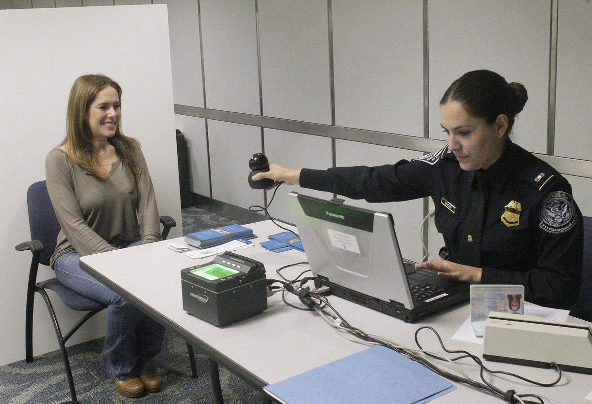 Mabel Rodríguez, una viajera de negocios frecuente, es fotografiada en el Aeropuerto Internacional de Miami por un agente de Aduanas y Fronteras para inscribirla en Global Entry.