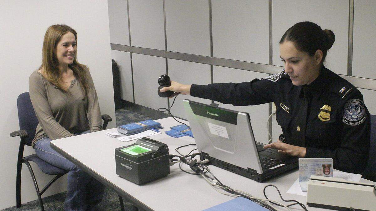 Mabel Rodríguez, una viajera de negocios frecuente, es fotografiada en el Aeropuerto Internacional de Miami por un agente de Aduanas y Fronteras para inscribirla en Global Entry.