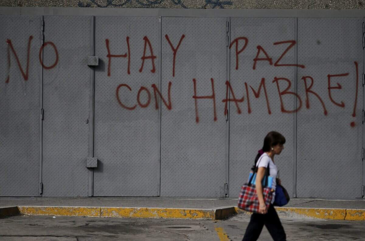 Una persona pasa junto a un grafiti en Caracas, Venezuela. Foto de archivo.