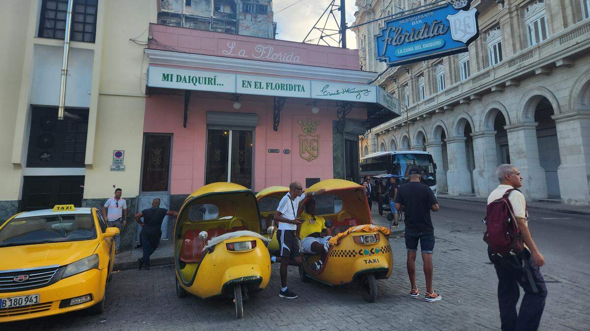 Un taxi y dos mototaxis esperan por clientes cerca del popular bar El Floridita, en La Habana, Cuba, el 7 de octubre de 2023.