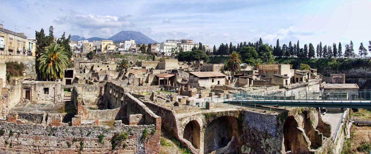Al igual que Pompeya, Herculano quedó enterrado bajo las cenizas de la erupción del Vesubio y más tarde fue redescubierta por las excavaciones arqueológicas.