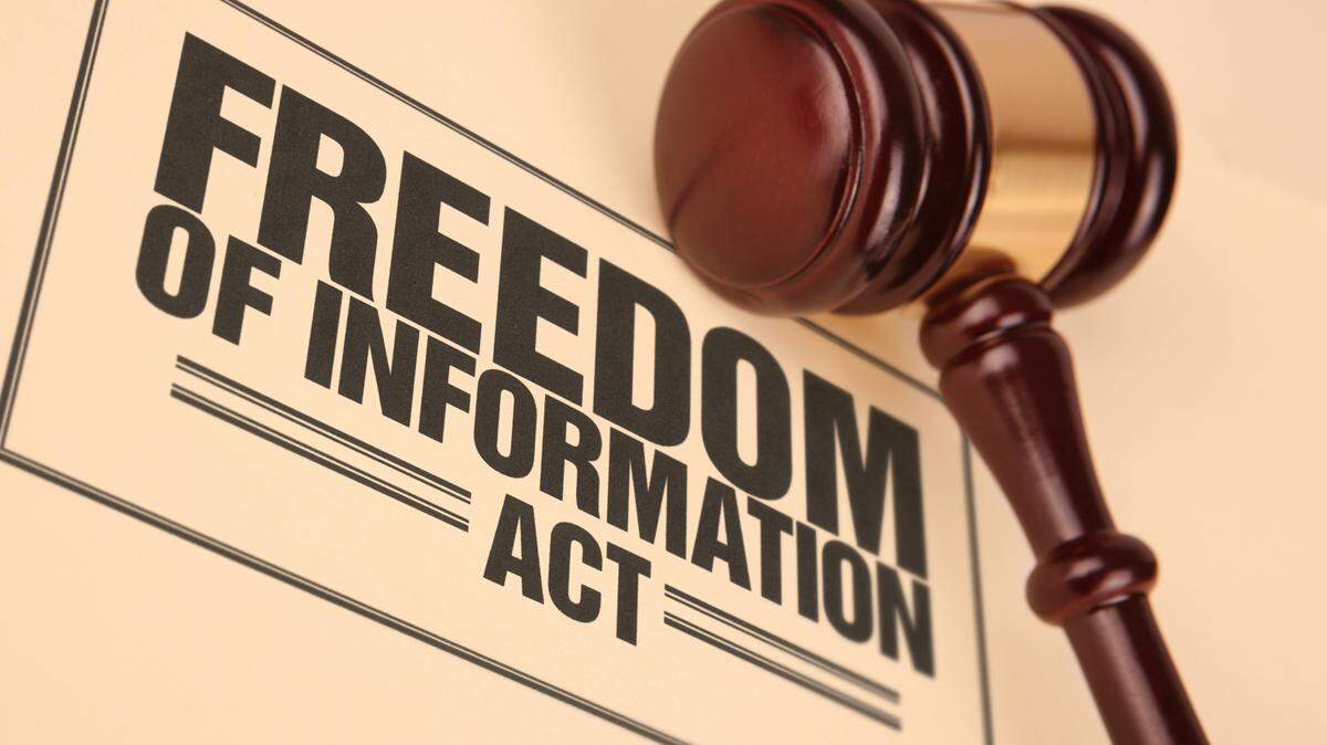 Freedom of information document near a gavel.  Stock image of justice and law.