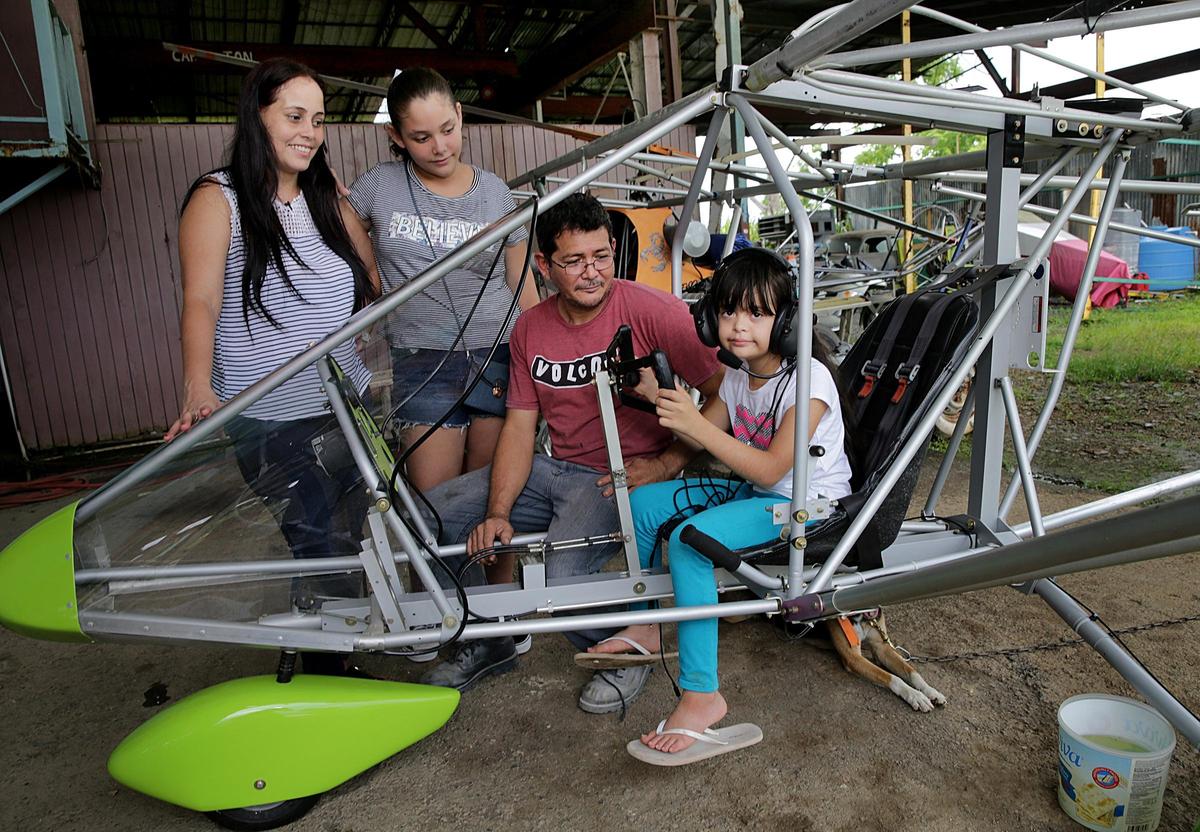 Yesenia Santiago y su esposo Roberto Colón, con sus hijas Yesenia (segunda desde la izquierda) y Marylee, de 10 años y quien sufre del síndrome de Down, posan en un avión ultraligero junto a su casa, en una imagen del 11 de agosto del 2018. A la familia le preocupa el cierre de la escuela de Marylee, la Parcelas María, que atendía a muchos alumnos con necesidades especiales en el poblado puertorriqueño de Añasco, casi un año después del paso devastador del huracán María.