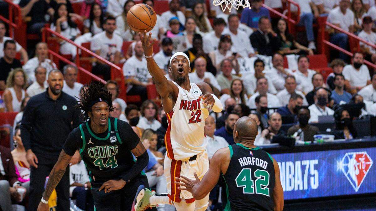 El jugador del Heat Jimmy Butler (22) entra al aro ante la marca de Robert Williams III (izq.) y Al Horford, de los Celtics de Boston, en el quinto partido de la Final de la Conferencia Este, celebrado el 25 de mayo de 2022 en Miami.