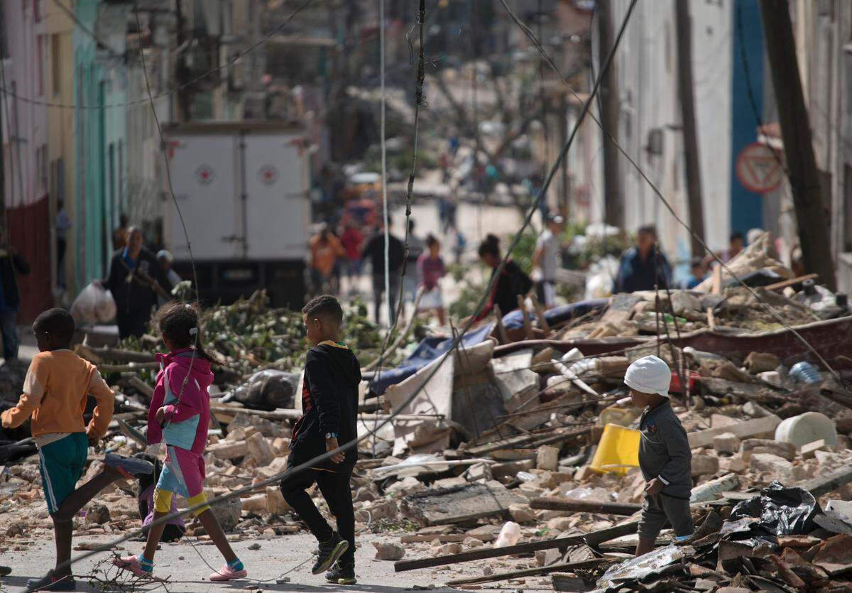 Children walk through the rubble on January 28, the day after a tornado hit neighborhoods in eastern Havana.