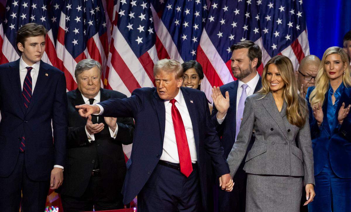 El presidente electo de Estados Unidos Donald Trump señala a la multitud durante su fiesta en la noche de las elecciones, flanqueado por familiares y amigos en el Centro de Convenciones del condado de Palm Beach, en Florida, el 5 de noviembre de 2024.