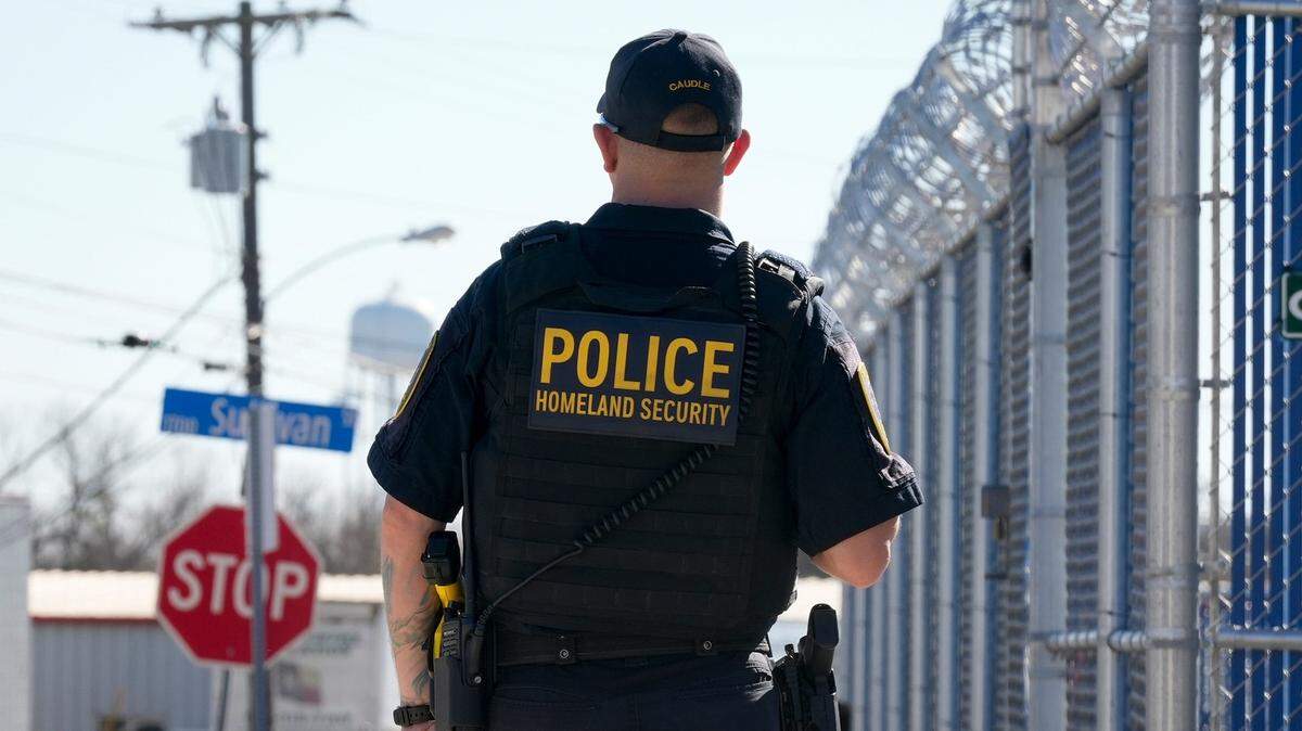 Un agente policial del Departamento de Seguridad Nacional observa una protesta contra las medidas antimigratorias del presidente Donald Trump, el 1 de febrero de 2025, en Pflugerville, Texas.
