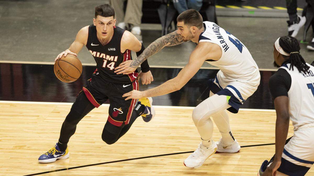 El escolta de Miami Heat, Tyler Herro (14), conduce a la canasta mientras el alero de los Minnesota Timberwolves, Juancho Hernangomez (41), defiende en el tercer cuarto en el AmericanAirlines Arena en Miami el viernes 7 de mayo de 2021.