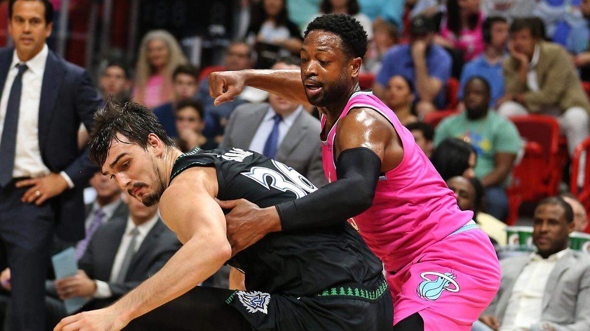El escolta del Heat Dwyane Wade (der.) trata de rescatar una pelota perdida de Dario Saric, de Minnesota, en el segundo cuarto del partido celebrado el 30 de diciembre de 2018 en Miami.