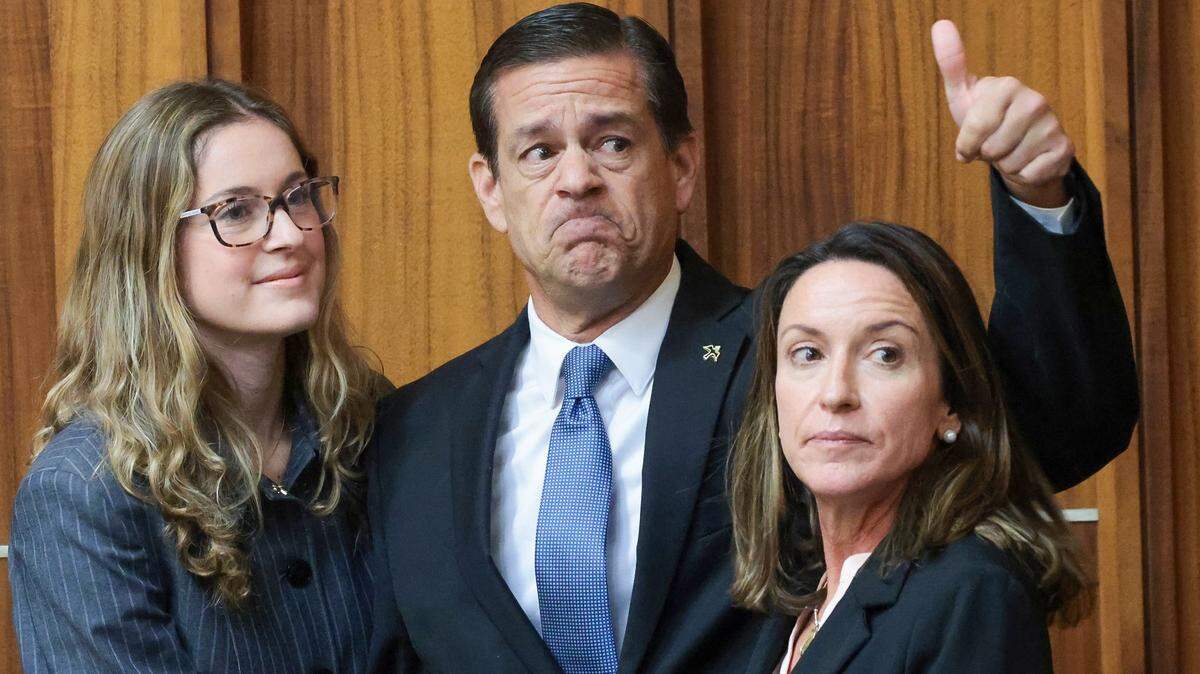 Flanqueado por su hija, Carolina Pino, a la izquierda, y su esposa, Cecilia Pino, el corredor de bienes raíces George Pino saluda a sus simpatizantes en el los tribunales Richard E. Gerstein el pasado 21 de noviembre.