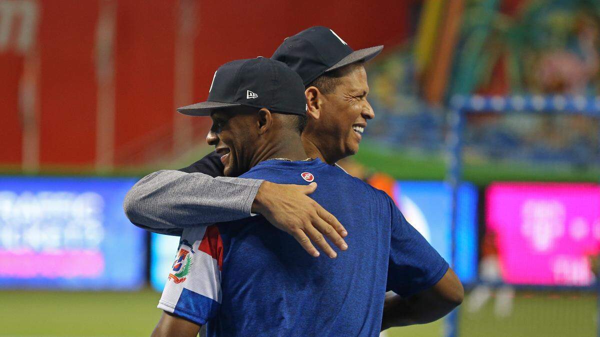 El tercera base de los Yankees Miguel Andújar (izq.) abraza al exjugador de los Yankees Alex Rodríguez horas antes del inicio del partido ante los Marlins, el 22 de agosto de 2018 en Miami.