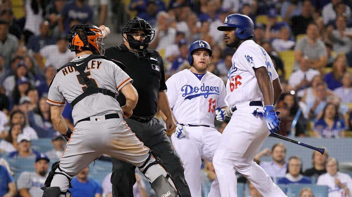 El jardinero de los Dodgers Yasiel Puig (der.) se enfrenta al receptor Nick Hundley, de los Gigantes de San Francisco, en el partido que se disputó el pasado martes 14 de agosto de 2018, en el Dodger Stadium, en Los Ángeles.