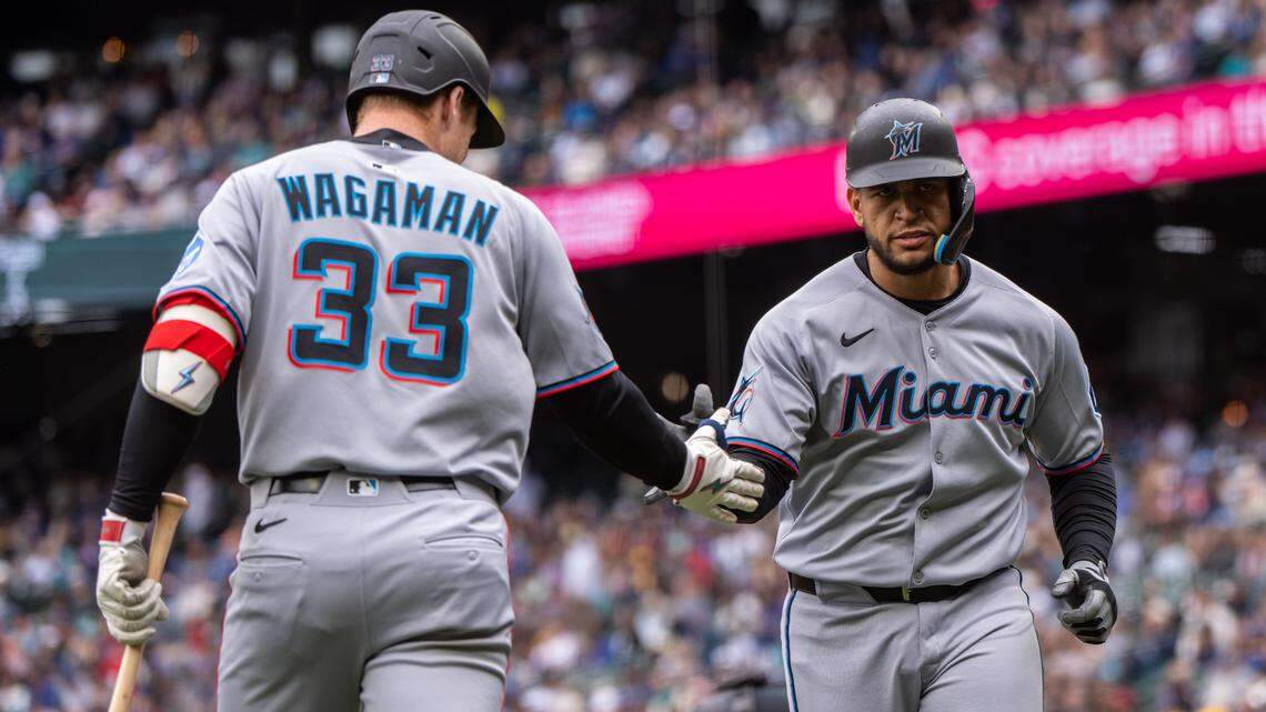 Apr 27, 2025; Seattle, Washington, USA; Miami Marlins designated hitter Agustin Ramirez (50) is congratulated by left fielder Eric Wagaman (33) during the first inning against the Seattle Mariners at Lumen Field. Mandatory Credit: Stephen Brashear-Imagn Images