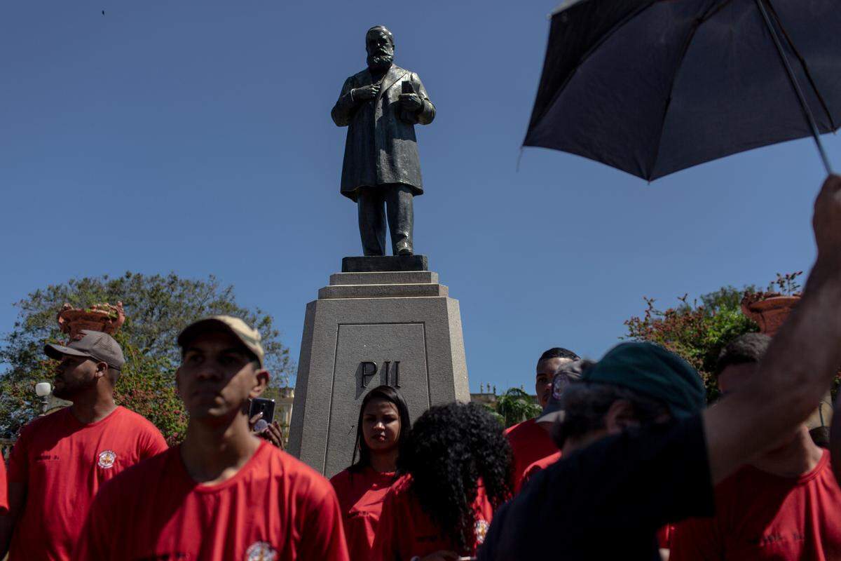 Un grupo de bomberos frente a la estatua de Don Pedro II, quien perteneció a la familia real portuguesa y que está ubicada frente al museo.