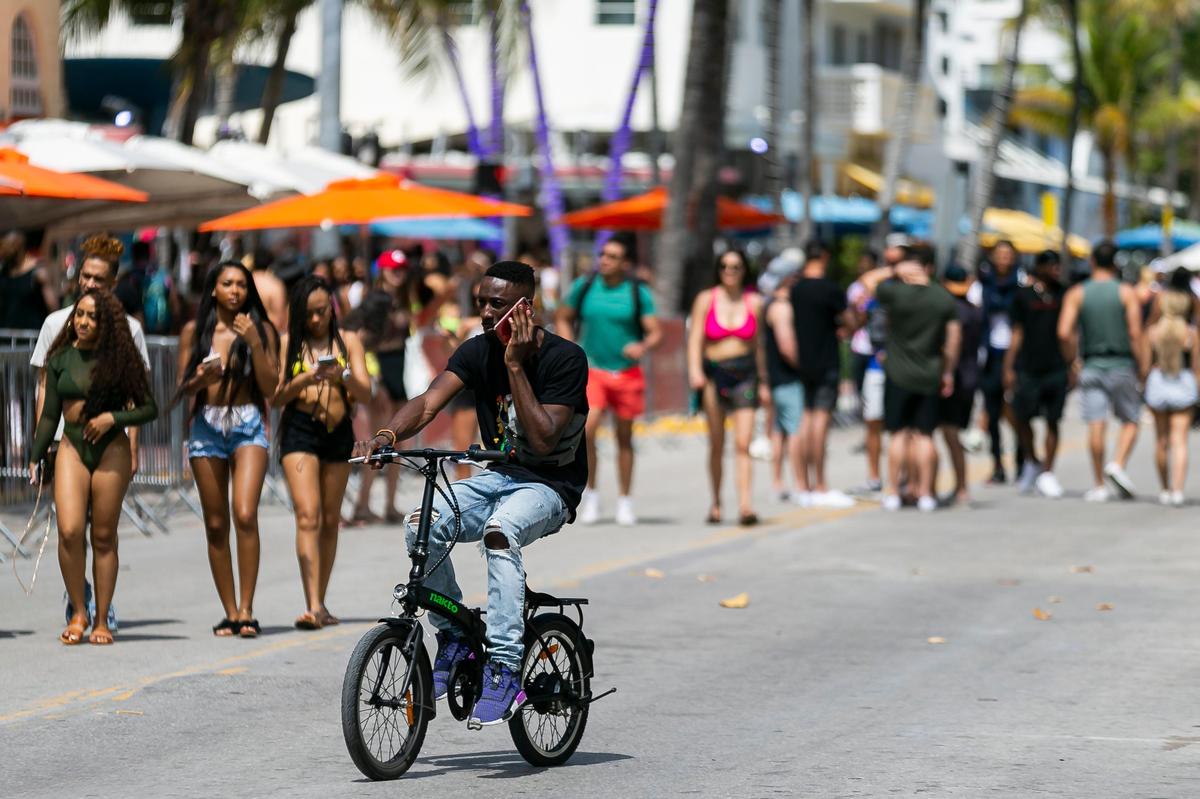 People walk down Ocean Drive on March 14 at the peak of spring break. Two days later, the city of Miami Beach started restricting beach activities. Now, city officials say they would have acted sooner if the state had shared information about the spread of COVID-19.