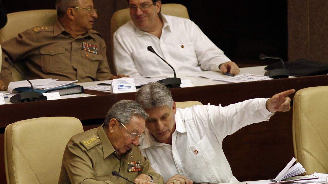 El gobernante cubano Raul Castro (izq) habla con el vicepresidente Miguel Diaz-Canel. Atrás el ministro de las fuerzas armadas Leopoldo Cintras Frias, (izq) junto al canciller Bruno Rodriguez, durante la sesión legislativa del 2013 en La Habana, Cuba. Foto de archivo.